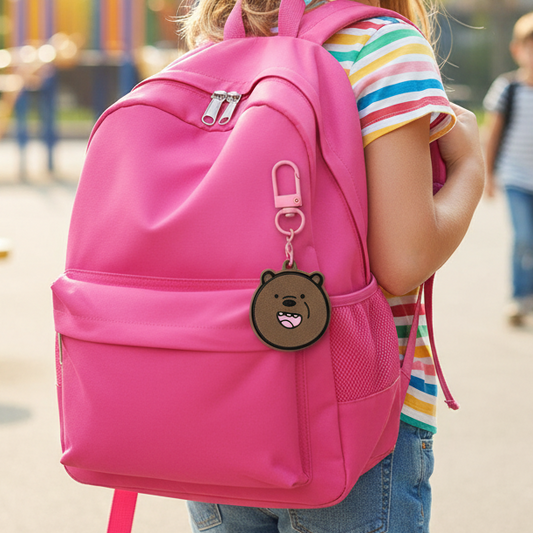 Bradley Bear Fidget Clicker Keychain clipped to a pink backpack carried by an elementary age girl